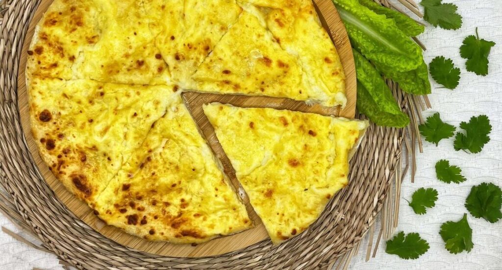 Осетинский пирог с картошкой и сыром на тарелке