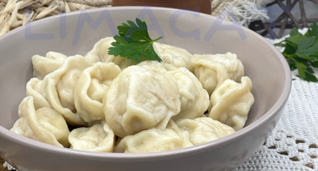 Пельмени с курицей в белой тарелке с кусочком петрушки